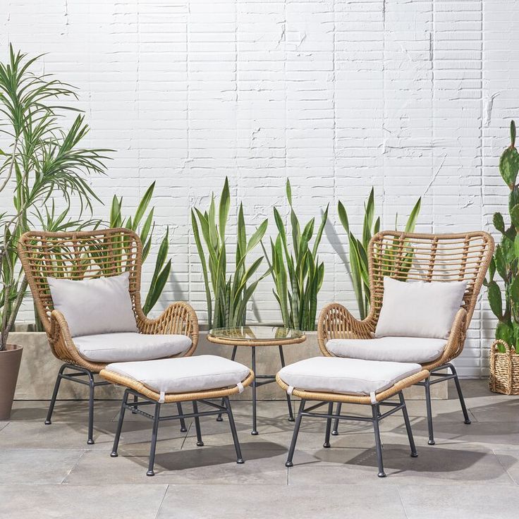 Outdoor wicker patio seating set with four cushioned chairs and round side table