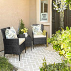 Outdoor patio furniture set with two dark wicker chairs and small table