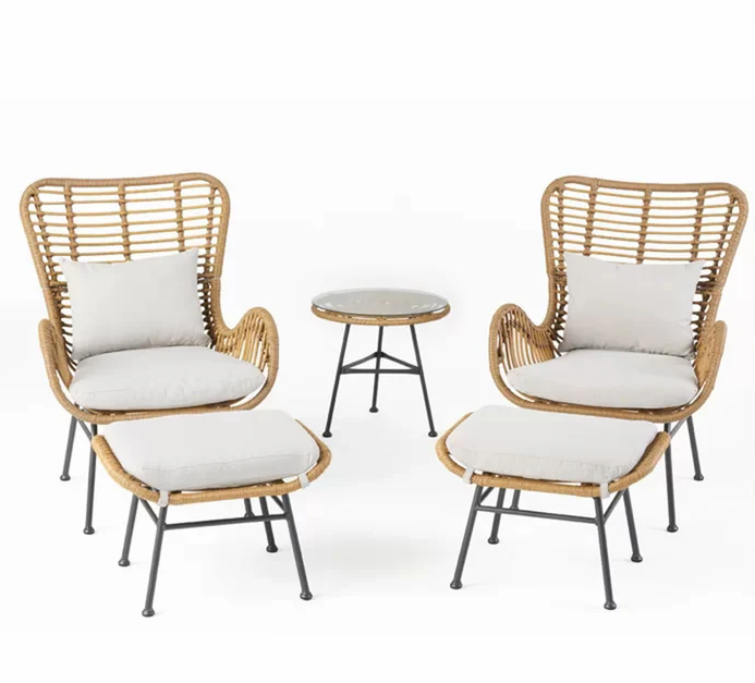 Two wicker armchairs with white cushions and round side table in between