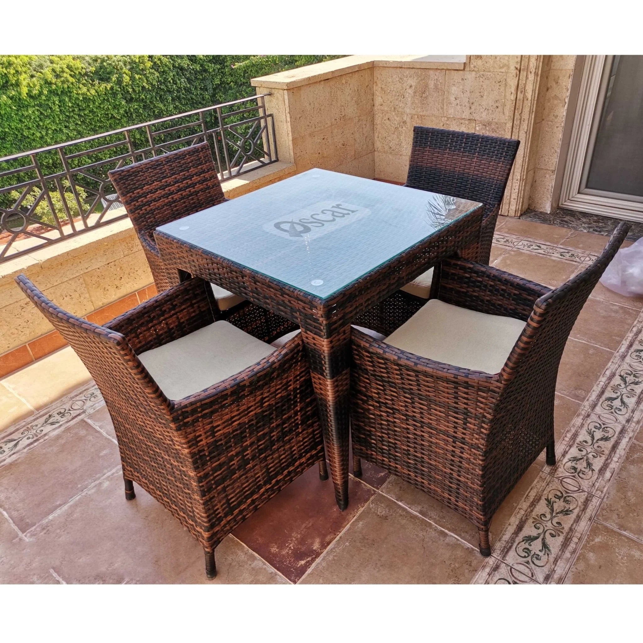 Outdoor rattan dining set for 4 with square glass-top table and four woven chairs