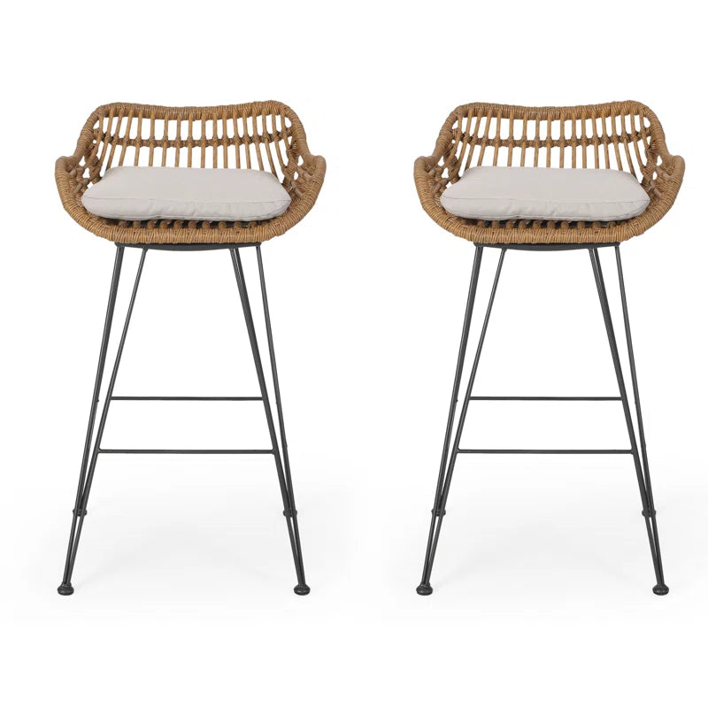 Pair of rattan bar stools with white seat cushions, curved backs, black metal legs