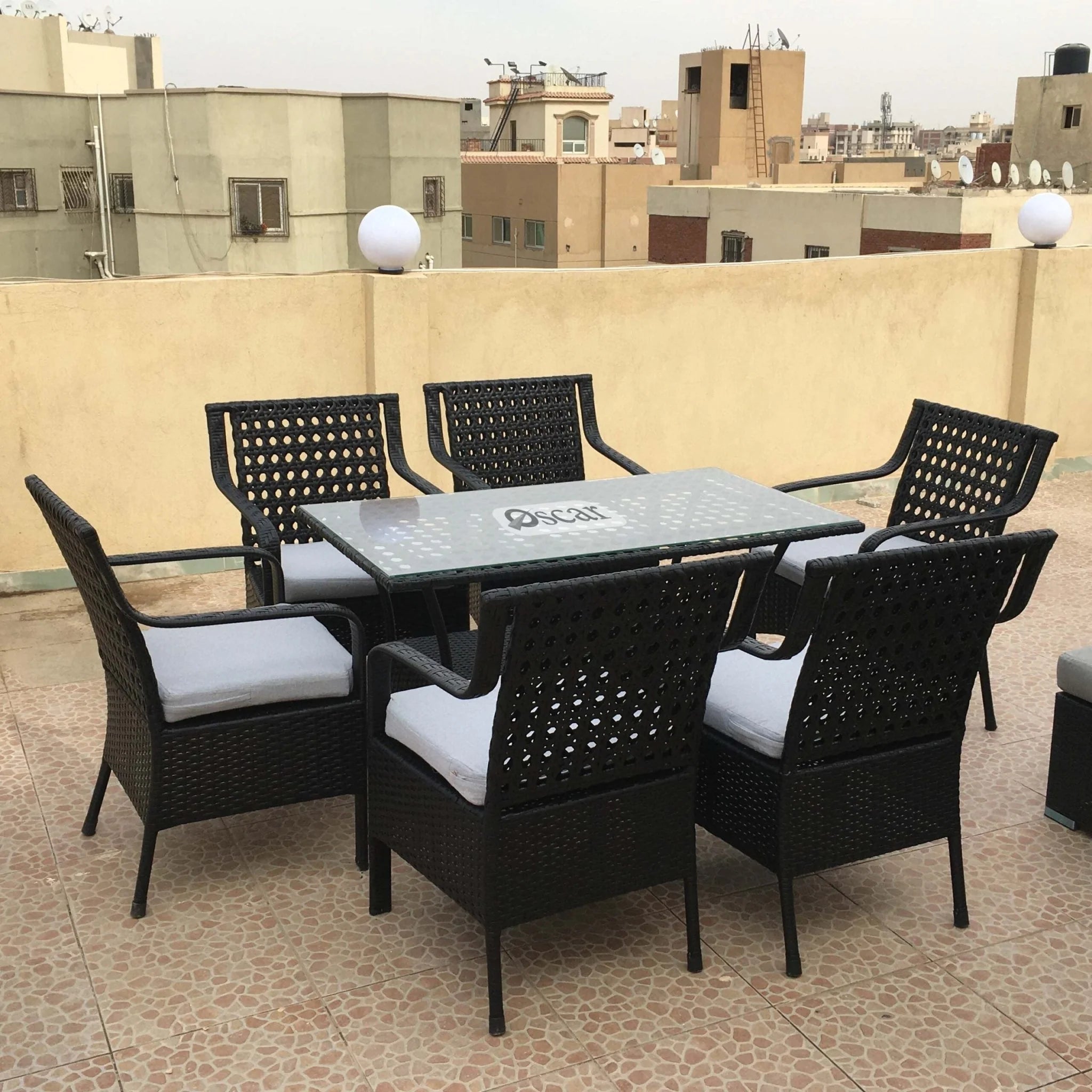 Marvel rattan dining set for 6 with black woven chairs and clear glass table, seat cushions