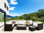 Outdoor lounge furniture set with dark wicker chairs, sectional sofa, white cushions, coffee table