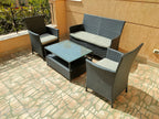 Patio seating set with dark woven loveseat, two armchairs, and rectangular glass table