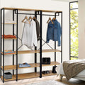 Black metal clothes rack with hanging bar and light wood shelves, open cubbies