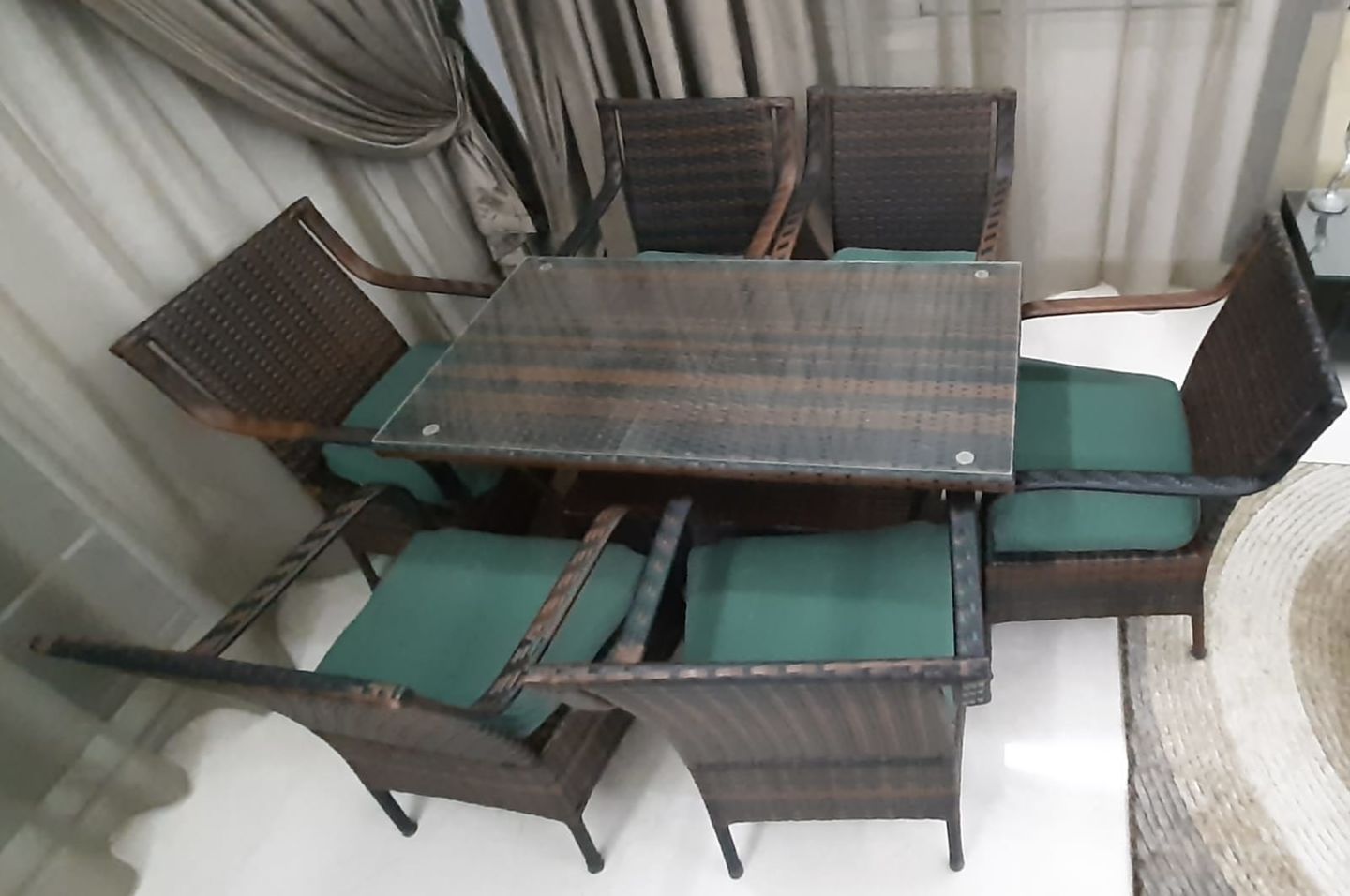Marvel rattan dining set for 6 with black woven chairs, clear glass table, green seat cushions