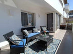 Rattan patio seating set with blue patterned cushions, matching chairs, coffee table