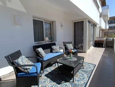 Rattan patio seating set with blue patterned cushions, matching chairs, coffee table